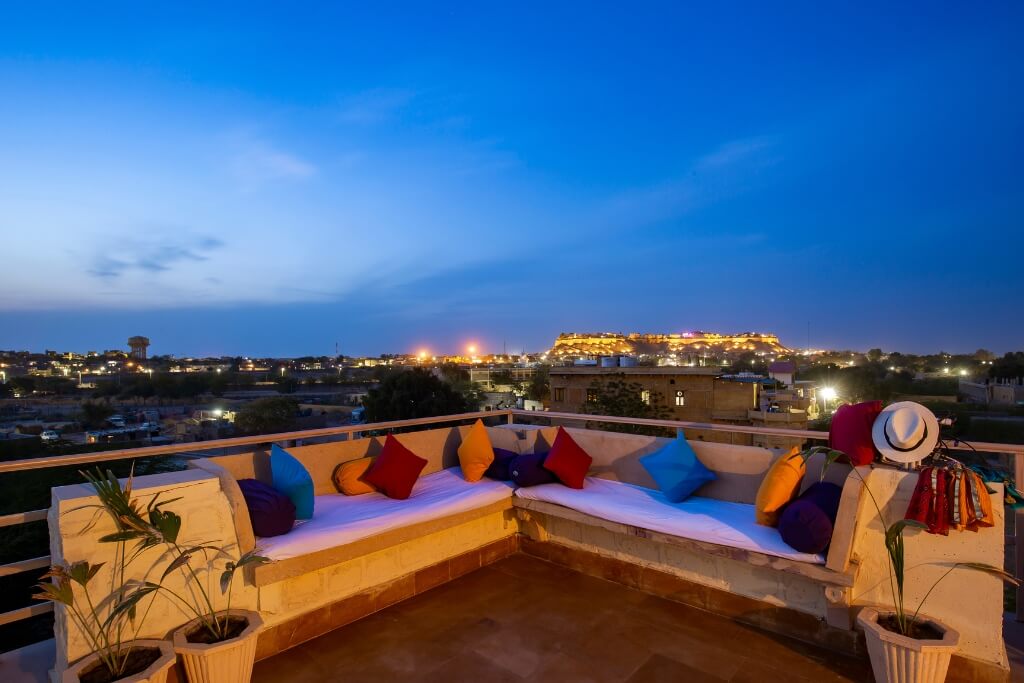 Rooftop terrace at night with Jaisalmer Fort view